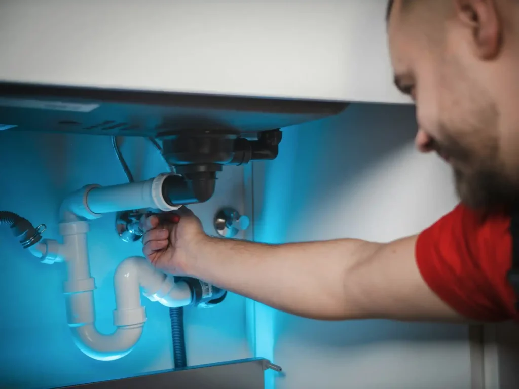 plombier qui débouche un siphon